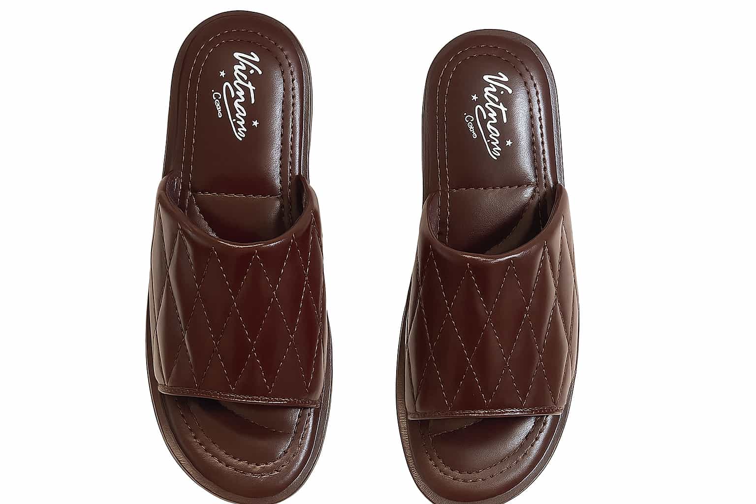 Pair of brown slippers with quilted design on a white background