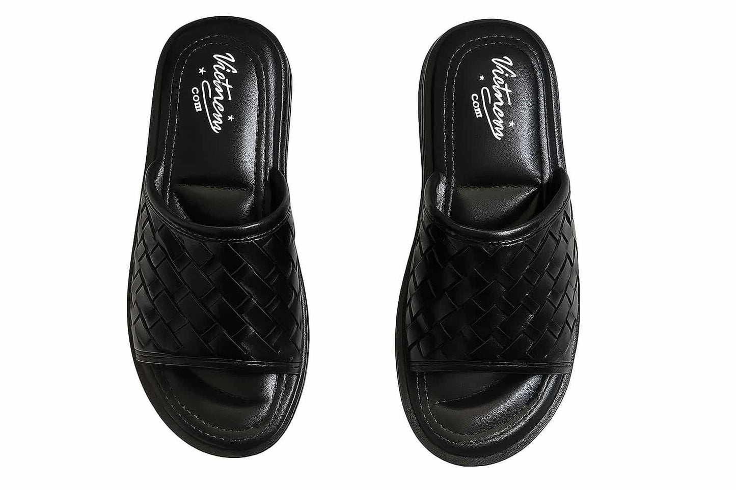 Pair of black woven slippers on a white background
