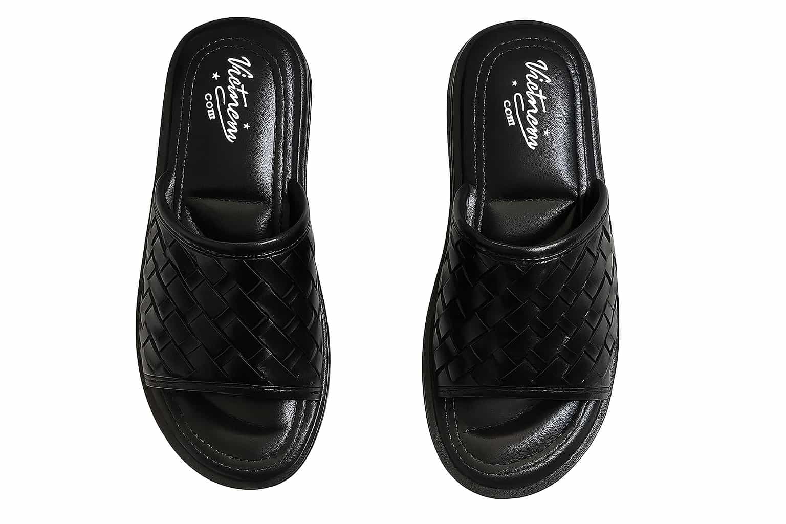 Pair of black woven slippers on a white background