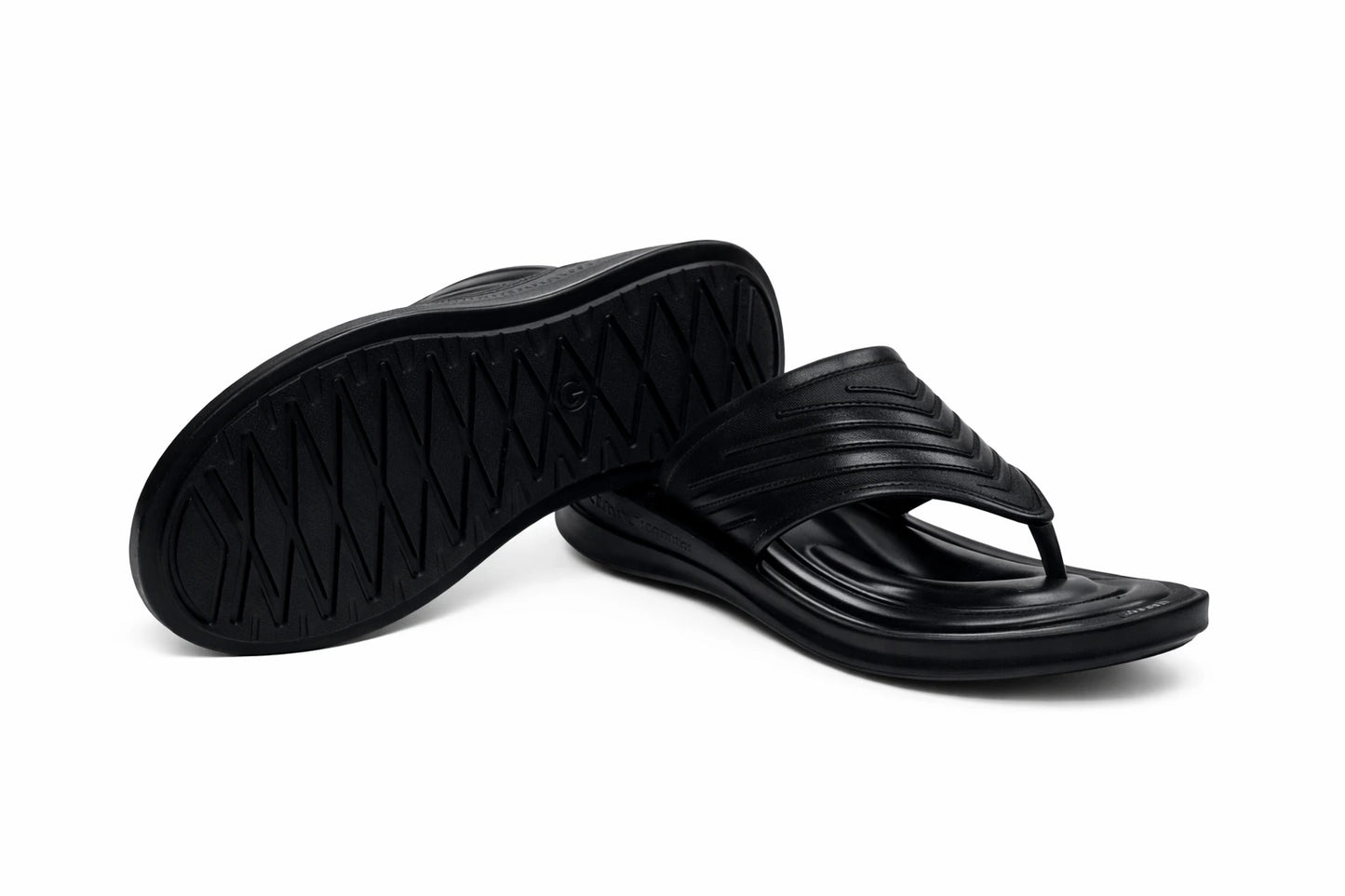 Black slippers with a textured sole on a white background